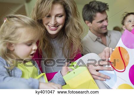Stock Photo - Happy family with shopping bags at home. Fotosearch