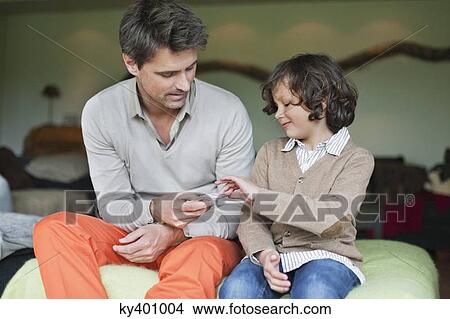 Picture - Man playing cards with his son. Fotosearch