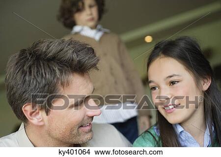 Picture - Man sitting with his daughter at home. Fotosearch