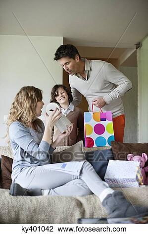 Man with his son giving surprise gift to his wife at home View Large Photo Image Stock Image - Man with his son giving surprise gift to his wife at home. Fotosearch