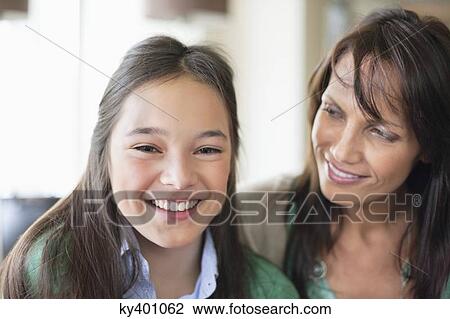 Stock Image - Portrait of a girl smiling with her mother. Fotosearch