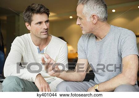 Picture - Two male friends discussing. Fotosearch