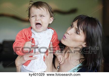 Stock Photo - Woman consoling her crying granddaughter. Fotosearch