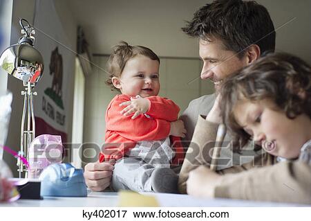 Stock Photo - Close-up of a man with his children at home. Fotosearch
