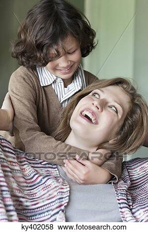 Close-up of a woman with his son smiling View Large Photo Image Stock Photo - Close-up of a woman with his son smiling. Fotosearch