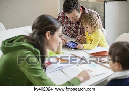 Couple teaching their children at home View Large Photo Image Picture - Couple teaching their children at home. Fotosearch