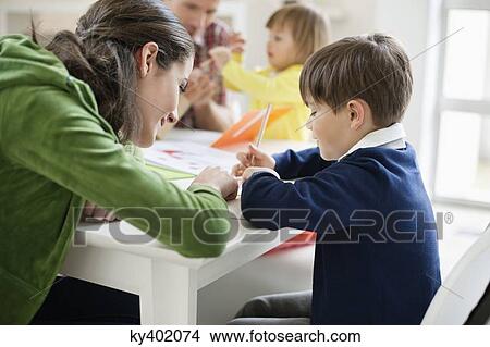 Couple teaching their children at home View Large Photo Image Picture - Couple teaching their children at home. Fotosearch
