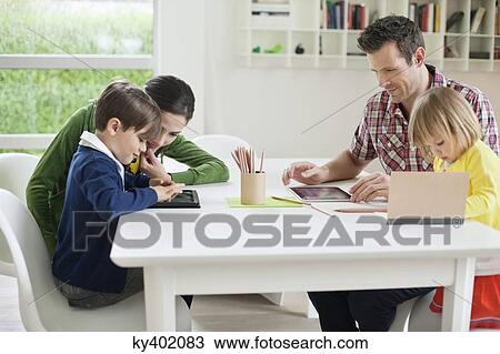 Couple teaching their children at home View Large Photo Image Stock Image - Couple teaching their children at home. Fotosearch