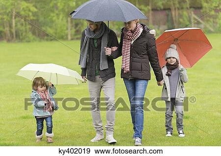 Family with umbrellas in a park View Large Photo Image Stock Photo - Family with umbrellas in a park. Fotosearch