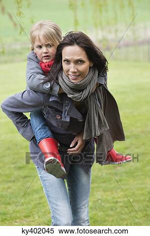 Girl riding piggyback on her mother View Large Photo Image Stock Photography - Girl riding piggyback on her mother. Fotosearch