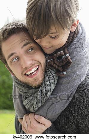 Happy boy riding piggyback on his father View Large Photo Image Stock Photograph - Happy boy riding piggyback on his father. Fotosearch
