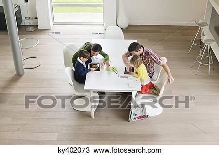 Stock Image - High angle view of couple teaching their children. Fotosearch