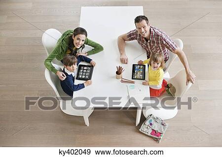 Stock Photo - High angle view of couple teaching their children. Fotosearch