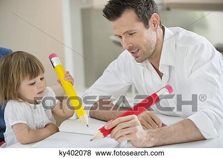 Man and daughter writing with big pencils View Large Photo Image Stock Photo - Man and daughter writing with big pencils. Fotosearch