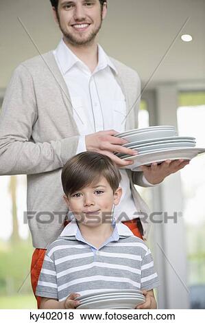 Man and son arranging plates for lunch View Large Photo Image Stock Photo - Man and son arranging plates for lunch. Fotosearch
