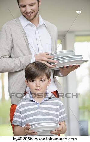Man and son arranging plates for lunch View Large Photo Image Stock Photograph - Man and son arranging plates for lunch. Fotosearch