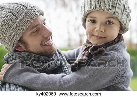 Man carrying his son in a park View Large Photo Image Stock Photo - Man carrying his son in a park. Fotosearch