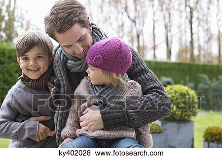 Stock Photo - Man hugging his two children. Fotosearch