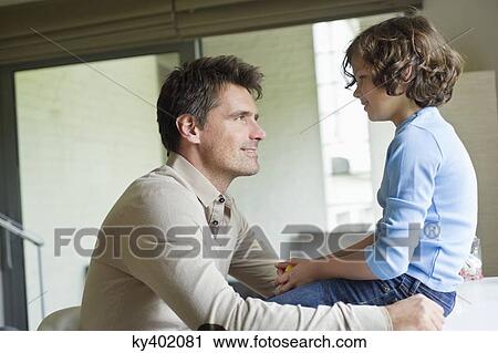 Man with his son looking at each other at home View Large Photo Image Stock Image - Man with his son looking at each other at home. Fotosearch