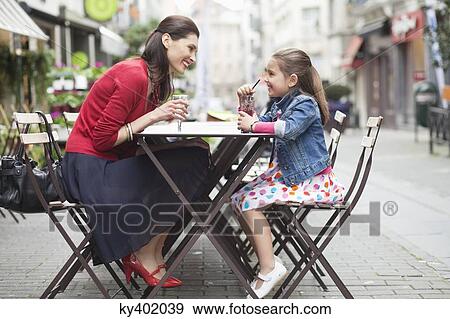 Woman and her daughter drinking at a sidewalk cafe View Large Photo Image Stock Photo - Woman and her daughter drinking at a sidewalk cafe. Fotosearch