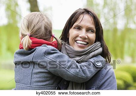 Stock Photography - Woman carrying her daughter. Fotosearch