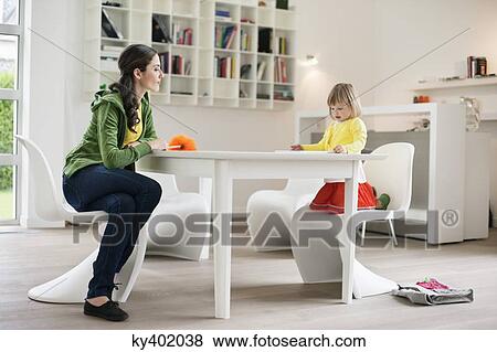 Stock Photo - Woman teaching her daughter at home. Fotosearch