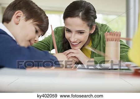Woman teaching her son at home View Large Photo Image Stock Photo - Woman teaching her son at home. Fotosearch