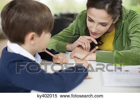 Stock Photography - Woman teaching her son at home. Fotosearch