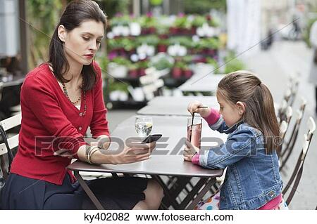 Stock Image - Woman with her daughter sitting in a cafe. Fotosearch