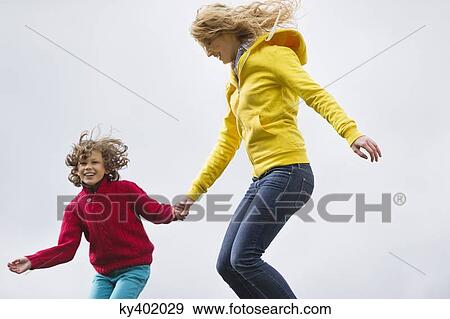 Woman with her son jumping and smiling View Large Photo Image Stock Photo - Woman with her son jumping and smiling. Fotosearch