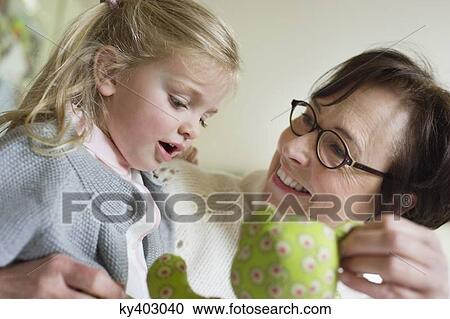 Stock Image - Close-up of a girl playing with her grandmother. Fotosearch