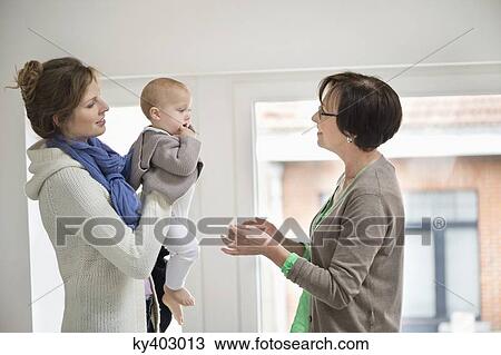 Woman giving her daughter to nanny View Large Photo Image Stock Image - Woman giving her daughter to nanny. Fotosearch