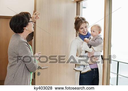 Woman with her daughter standing at the doorway View Large Photo Image Stock Photo - Woman with her daughter standing at the doorway. Fotosearch