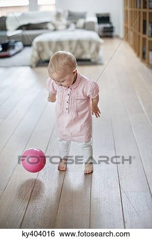 Baby girl playing with a ball View Large Photo Image Stock Photograph - Baby girl playing with a ball. Fotosearch