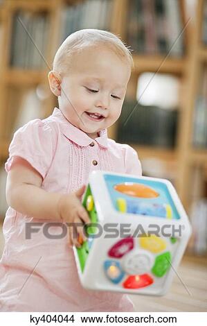 Baby girl playing with a musical block toy View Large Photo Image Picture - Baby girl playing with a musical block toy. Fotosearch