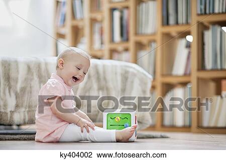 Baby girl playing with a musical block toy View Large Photo Image Stock Image - Baby girl playing with a musical block toy. Fotosearch