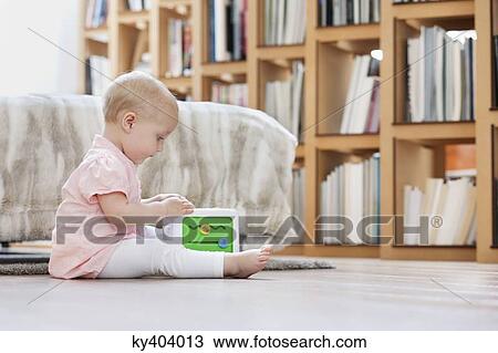 Baby girl playing with a musical block toy View Large Photo Image Stock Image - Baby girl playing with a musical block toy. Fotosearch