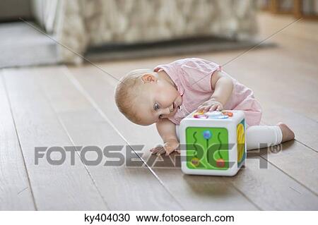 Baby girl playing with a musical block toy View Large Photo Image Stock Image - Baby girl playing with a musical block toy. Fotosearch