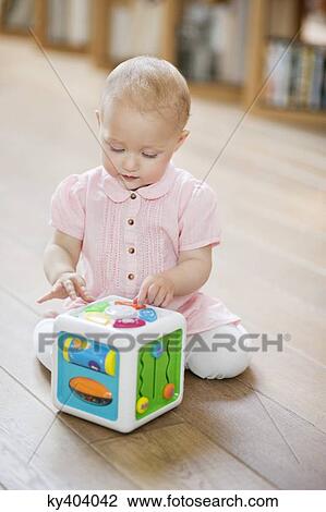 Baby girl playing with a musical block toy View Large Photo Image Stock Image - Baby girl playing with a musical block toy. Fotosearch