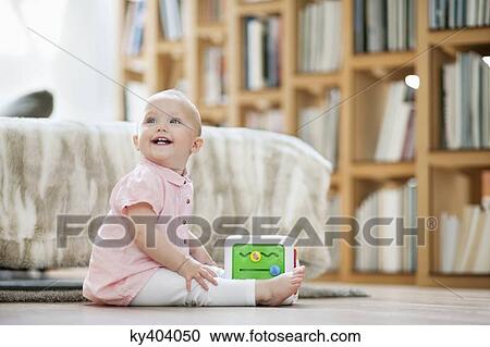 Baby girl playing with a musical block toy View Large Photo Image Stock Image - Baby girl playing with a musical block toy. Fotosearch