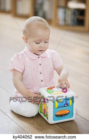 Baby girl playing with a musical block toy View Large Photo Image Stock Image - Baby girl playing with a musical block toy. Fotosearch