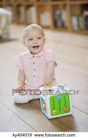 Baby girl playing with a musical block toy View Large Photo Image Stock Photo - Baby girl playing with a musical block toy. Fotosearch
