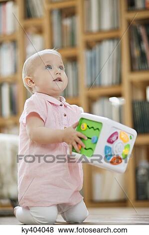 Baby girl playing with a musical block toy View Large Photo Image Stock Photo - Baby girl playing with a musical block toy. Fotosearch