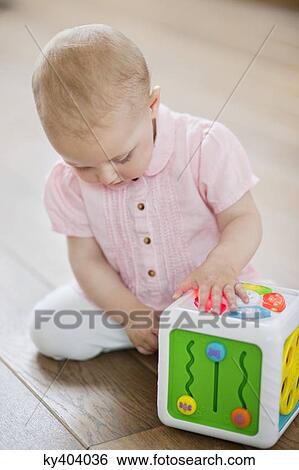 Stock Photograph - Baby girl playing with a musical block toy. Fotosearch