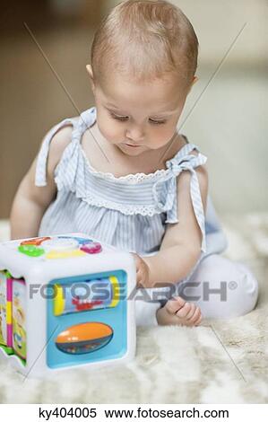 Baby girl playing with a musical block toy View Large Photo Image Stock Photography - Baby girl playing with a musical block toy. Fotosearch