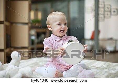 Stock Photograph - Baby girl playing with a tambourine. Fotosearch