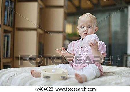 Stock Photo - Baby girl playing with a toy. Fotosearch