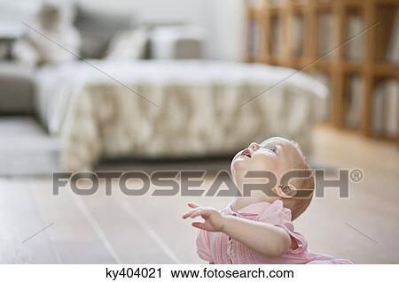 Stock Image - Close-up of a baby girl looking up. Fotosearch