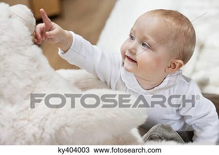Close-up of a baby girl playing with a teddy bear View Large Photo Image Stock Image - Close-up of a baby girl playing with a teddy bear. Fotosearch