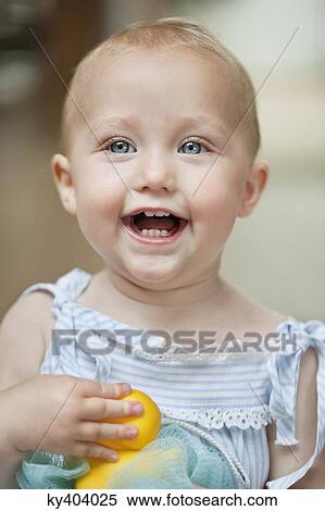 Stock Photography - Close-up of a baby girl playing with a toy and laughing. Fotosearch